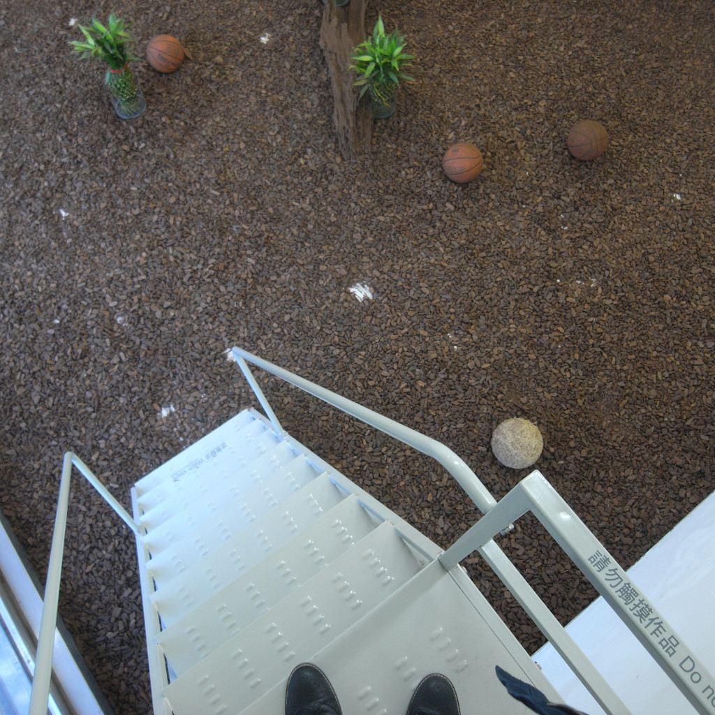 Luo Jr-Shin "Terrarium": Aerial view of the installation ground with wooden chips and basketballs.